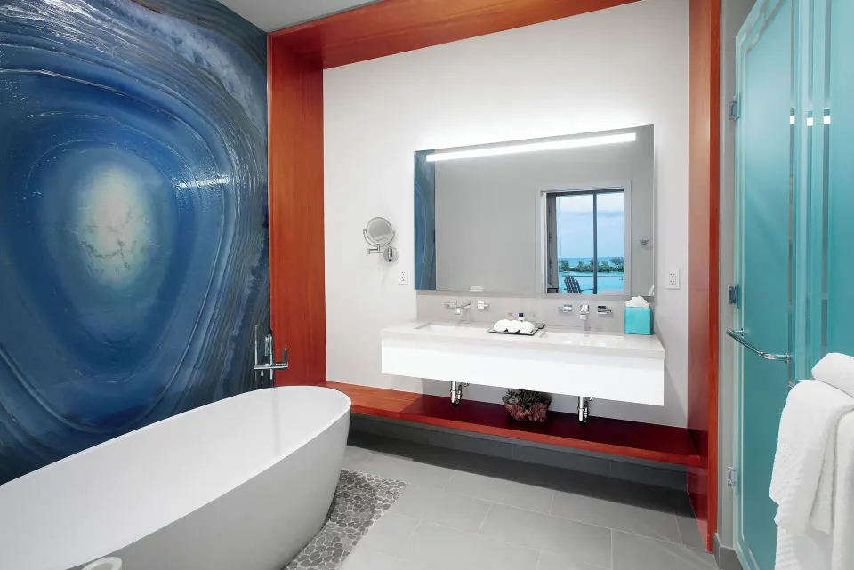 Suite bathroom at Margaritaville Beach Resort - Nassau with tub, vanity, and glass shower.