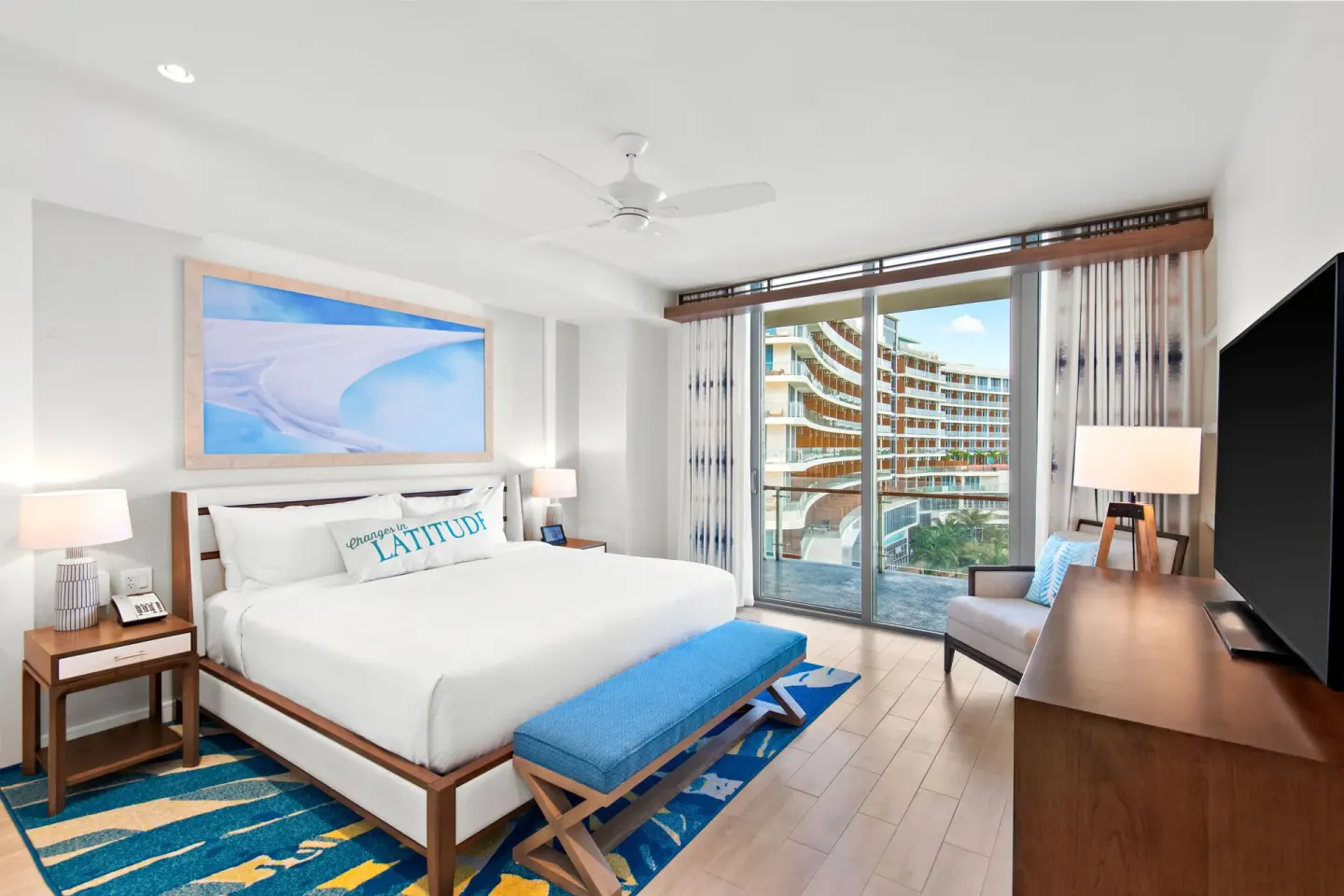 Oceanfront one-bedroom suite king bed at Margaritaville Beach Resort - Nassau with balcony doors.