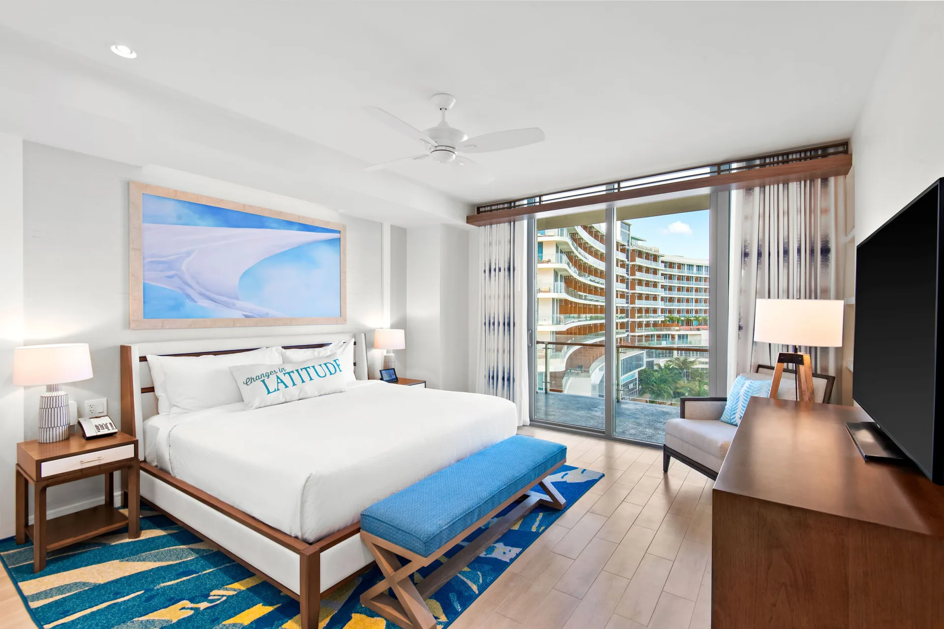 Oceanfront one-bedroom suite king bed at Margaritaville Beach Resort - Nassau with balcony doors.