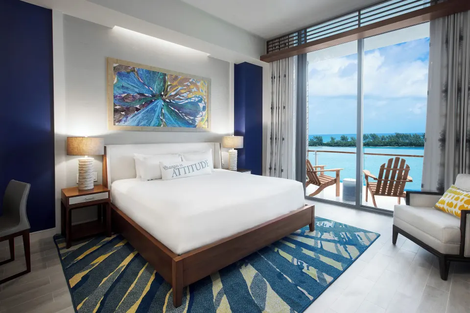 King bedroom at Margaritaville Beach Resort - Nassau with balcony chairs and ocean view.