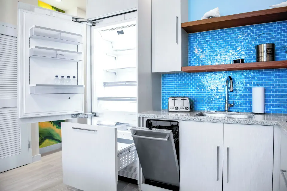 Suite kitchen with open refrigerator and dishwasher at Margaritaville Beach Resort - Nassau.