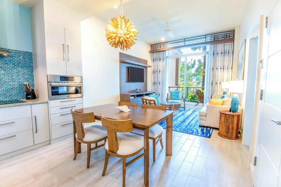 Suite living and dining area at Margaritaville Beach Resort - Nassau with kitchen and balcony doors.