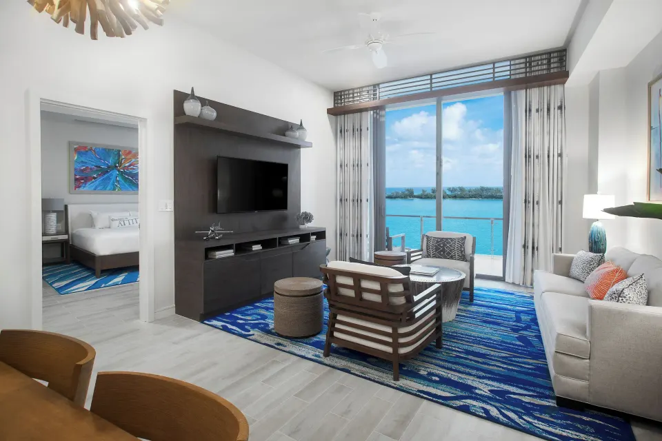 Oceanfront suite living room at Margaritaville Beach Resort - Nassau with balcony and bedroom doorway.