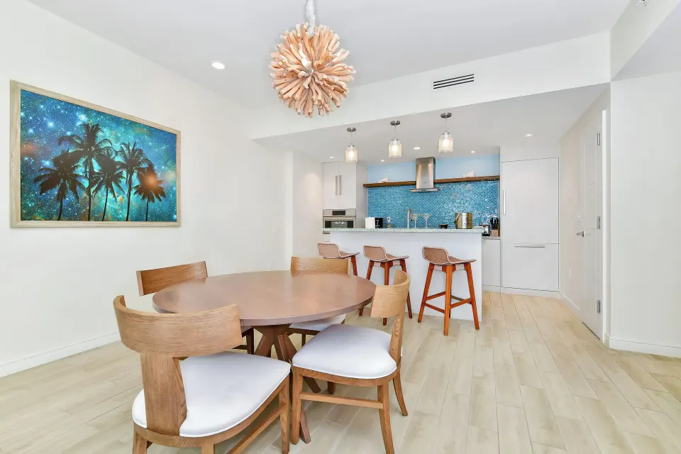 Oceanfront suite dining table and kitchen at Margaritaville Beach Resort - Nassau with tropical wall art.