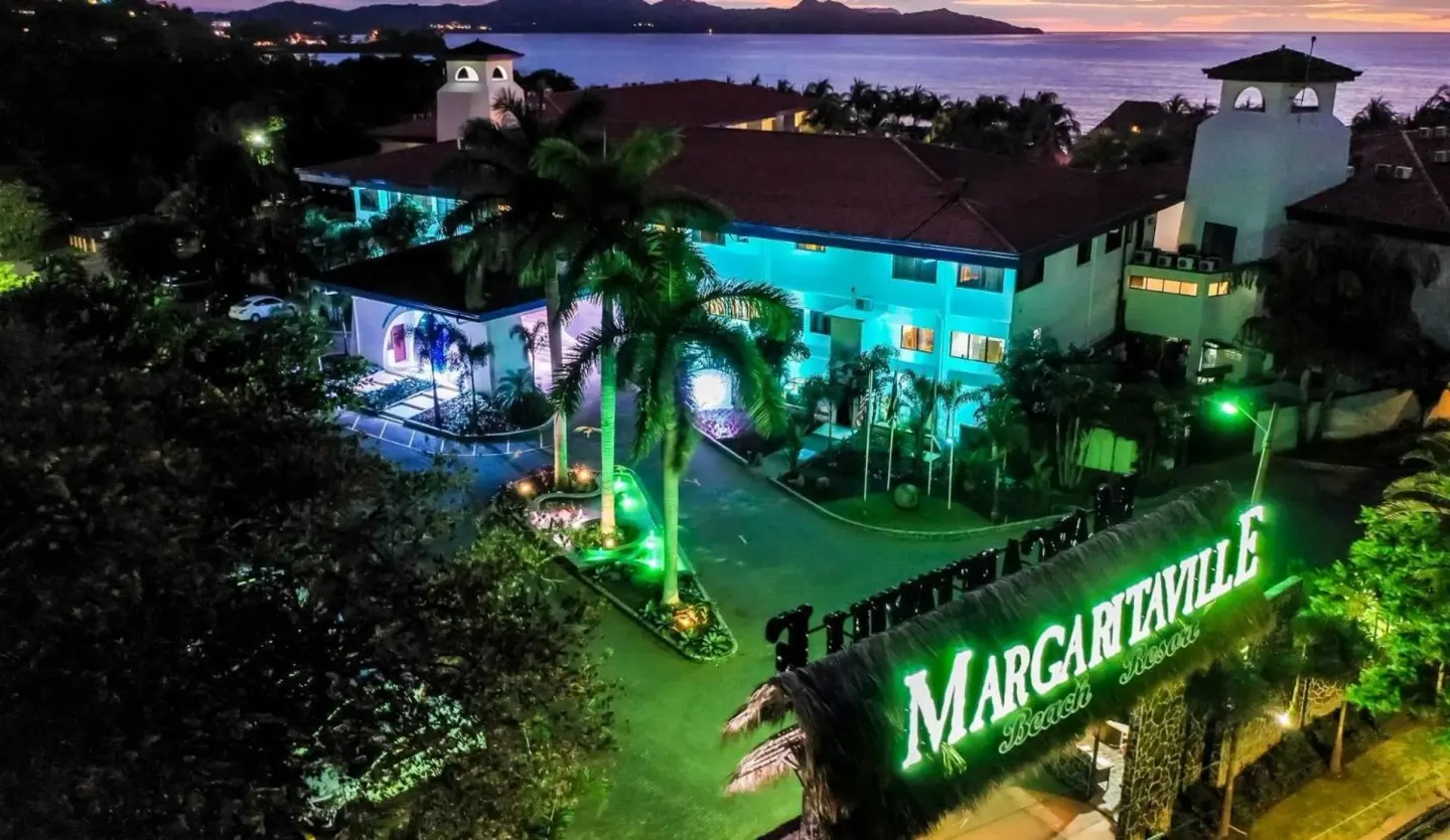 Aerial evening view of the resort entrance and ocean at Margaritaville Beach Resort Playa Flamingo.