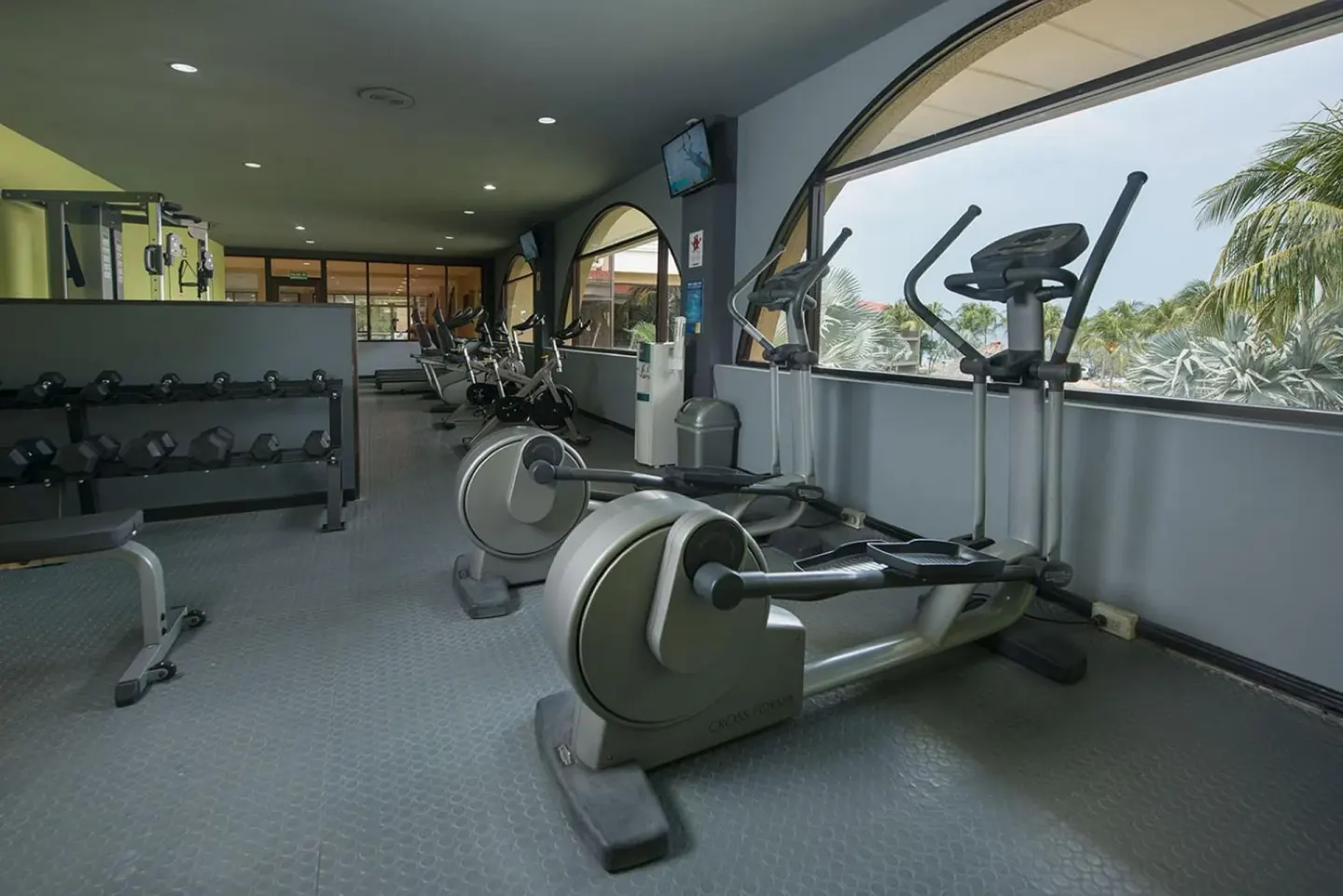 Fitness center with ellipticals, bikes and dumbbells at Margaritaville Beach Resort Playa Flamingo.