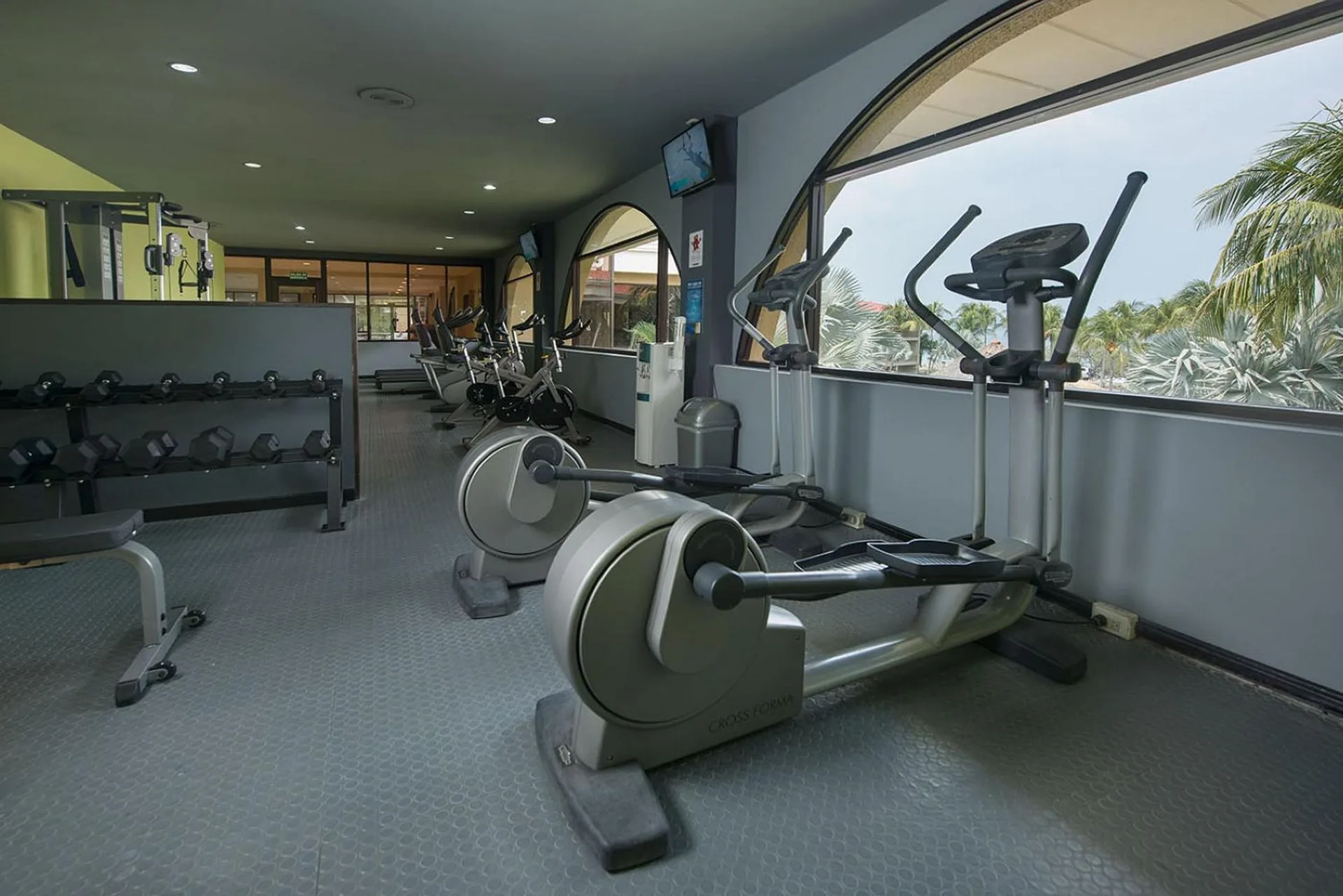 Fitness center with ellipticals, bikes and dumbbells at Margaritaville Beach Resort Playa Flamingo.