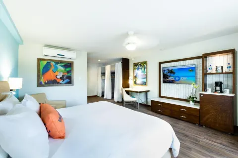 King bed and media cabinet in a guest room at Margaritaville Beach Resort Playa Flamingo.