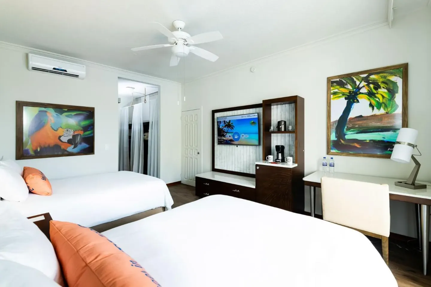 Two-bed guest room with desk and TV at Margaritaville Beach Resort Playa Flamingo.