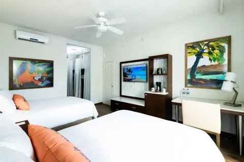 Two-bed guest room with desk and TV at Margaritaville Beach Resort Playa Flamingo.