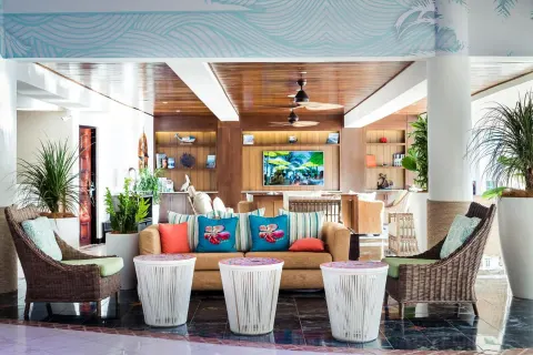 Lobby seating with wicker chairs and colorful pillows at Margaritaville Beach Resort Playa Flamingo.