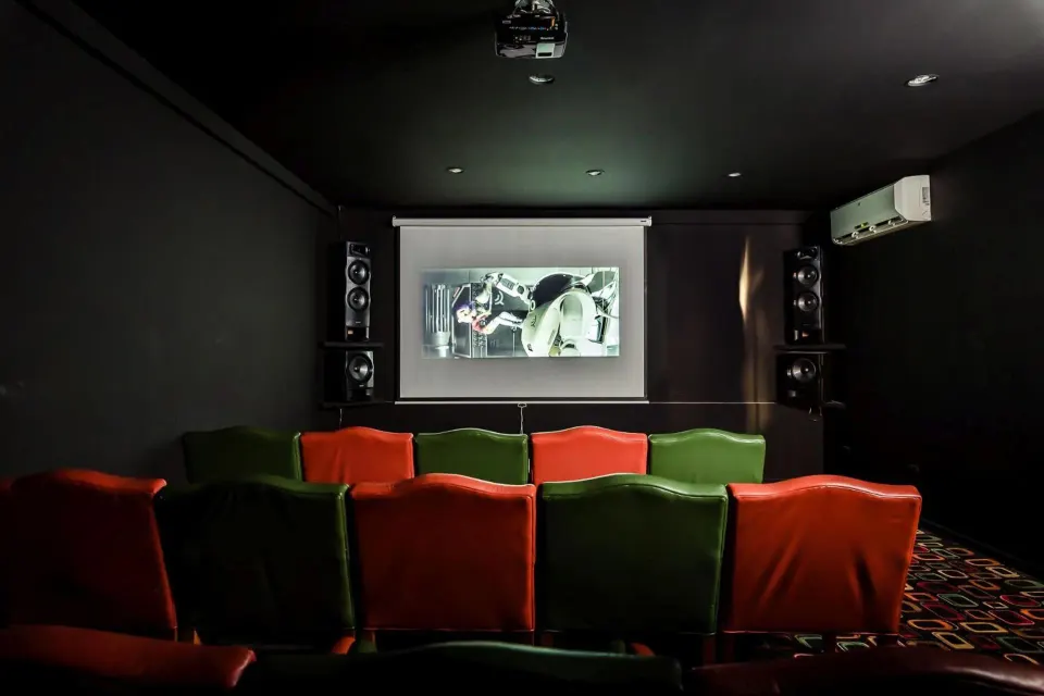 Small theater room with red and green seats at Margaritaville Beach Resort Playa Flamingo.