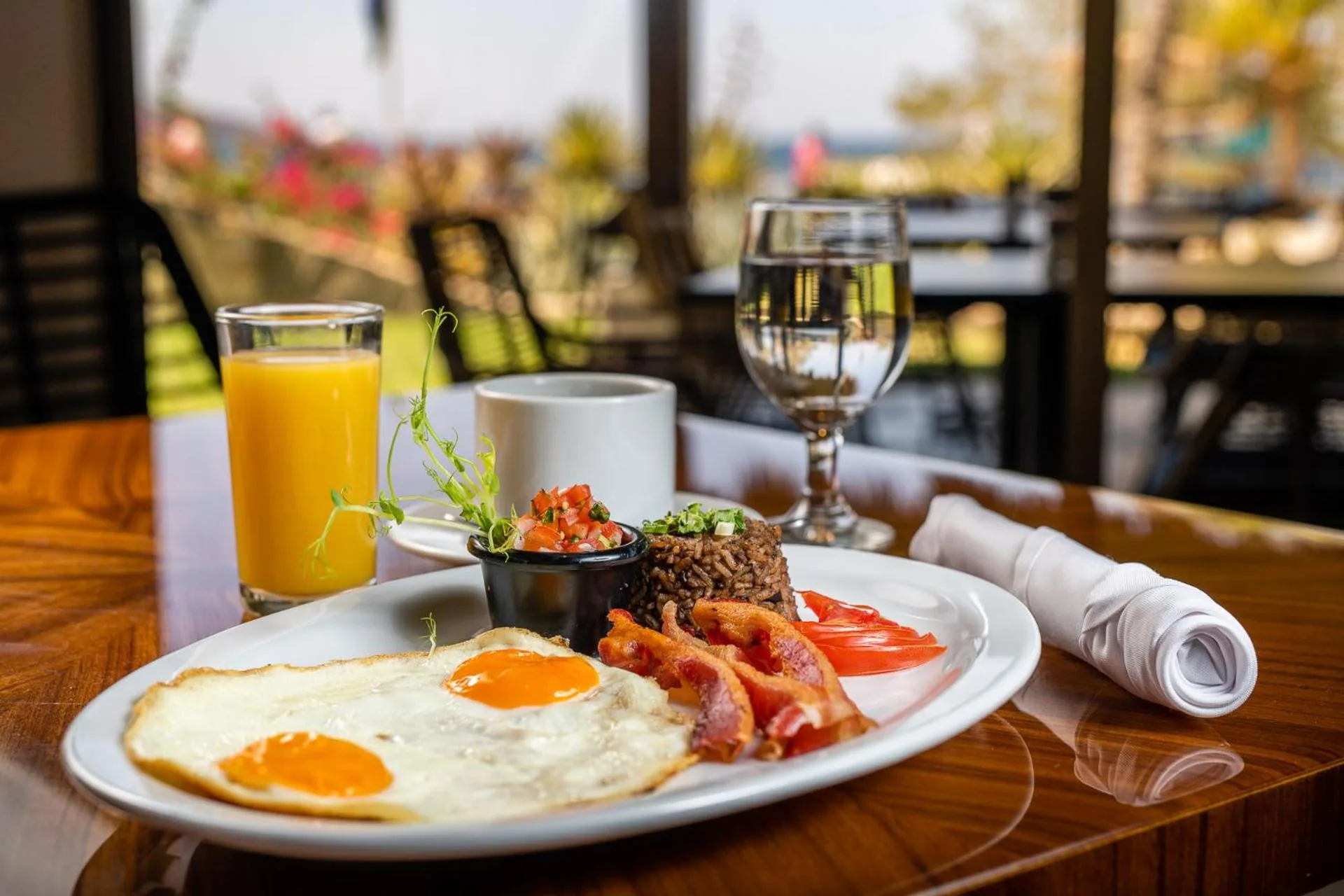 Breakfast plate with eggs, bacon, rice, juice, and coffee at Margaritaville Beach Resort Playa Flamingo.