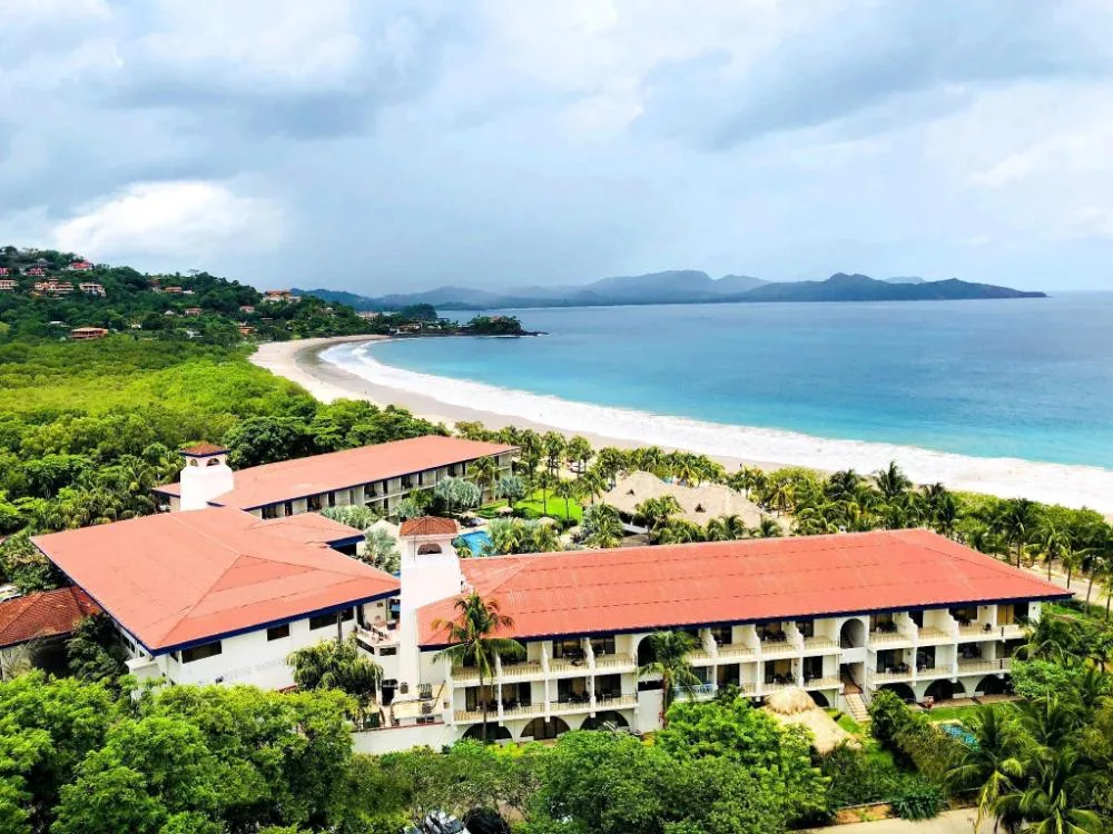 Aerial view of Margaritaville Beach Resort Playa Flamingo beside the beach and blue bay.