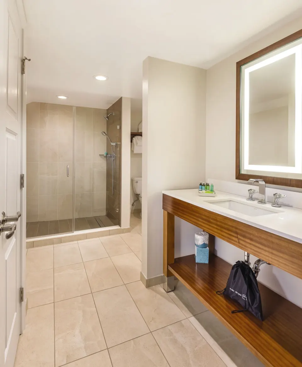 Guest bathroom with vanity and glass shower at Margaritaville Vacation Club - St. Thomas.