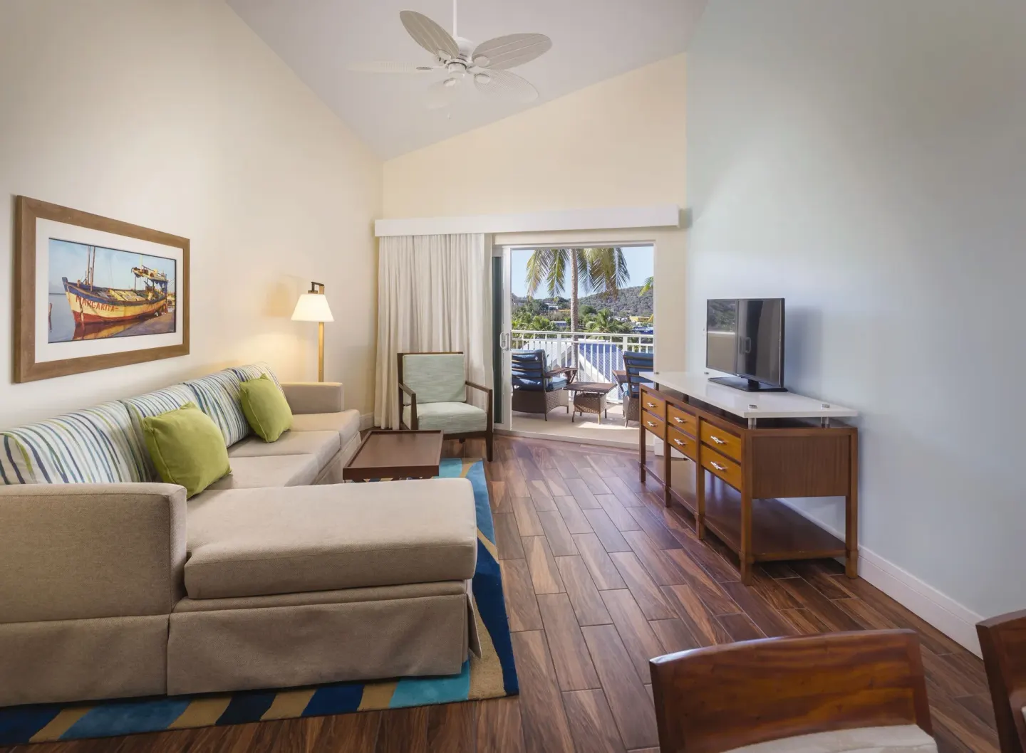 Guest room living area with sofa and balcony at Margaritaville Vacation Club - St. Thomas.