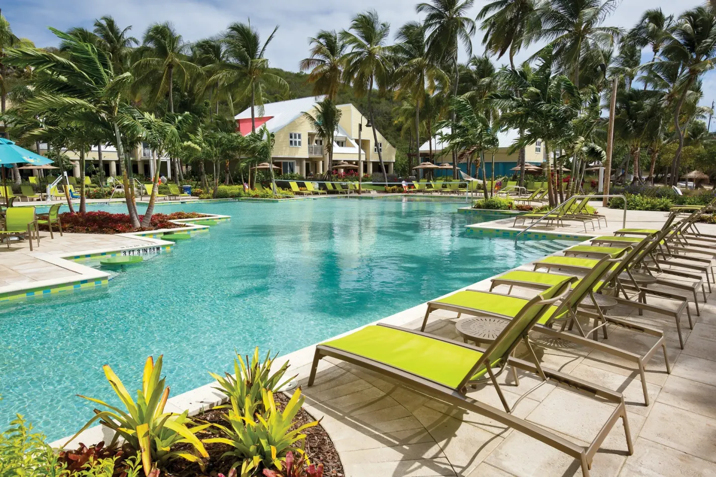 Main pool with lime lounge chairs and palms at Margaritaville Vacation Club - St. Thomas.