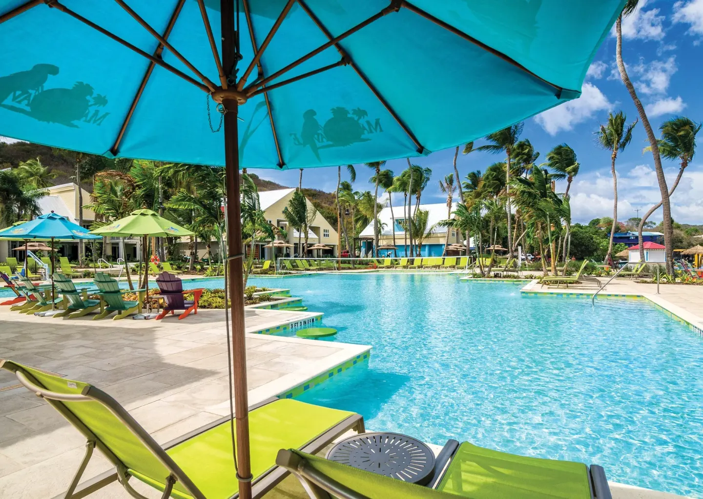 Pool deck with turquoise umbrella and loungers at Margaritaville Vacation Club - St. Thomas.