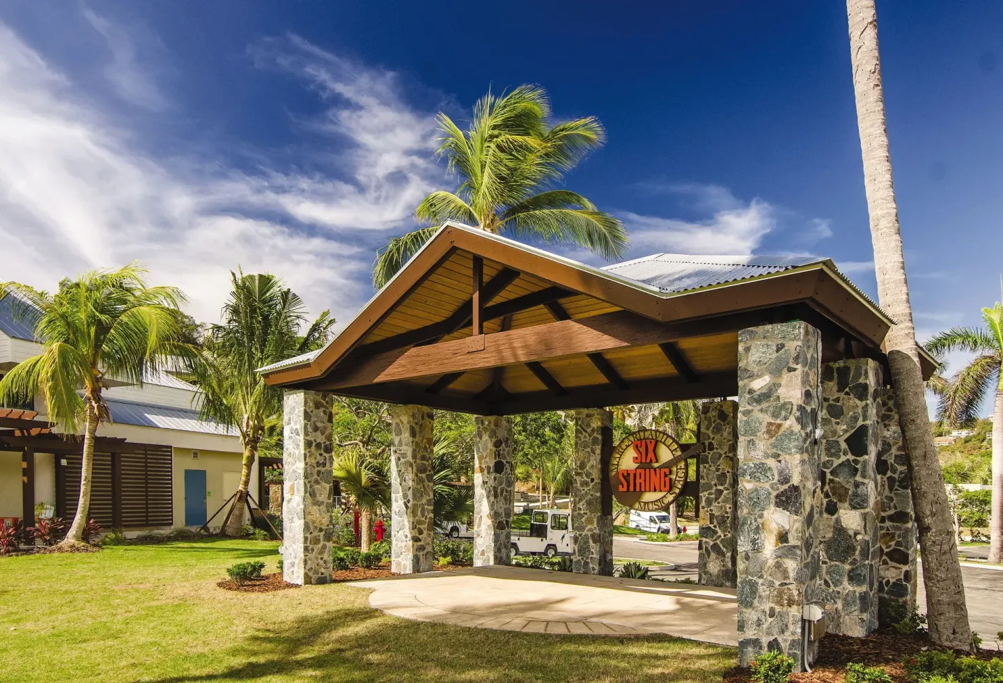 Stone entry pavilion and lawn with palm trees at Margaritaville Vacation Club - St. Thomas.