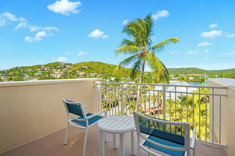 Standard 1 Bedroom condo balcony with chairs and hillside view at Margaritaville Vacation Club - St. Thomas.