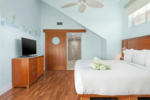 Bedroom with king bed and bathroom entry at Margaritaville Vacation Club - St. Thomas.