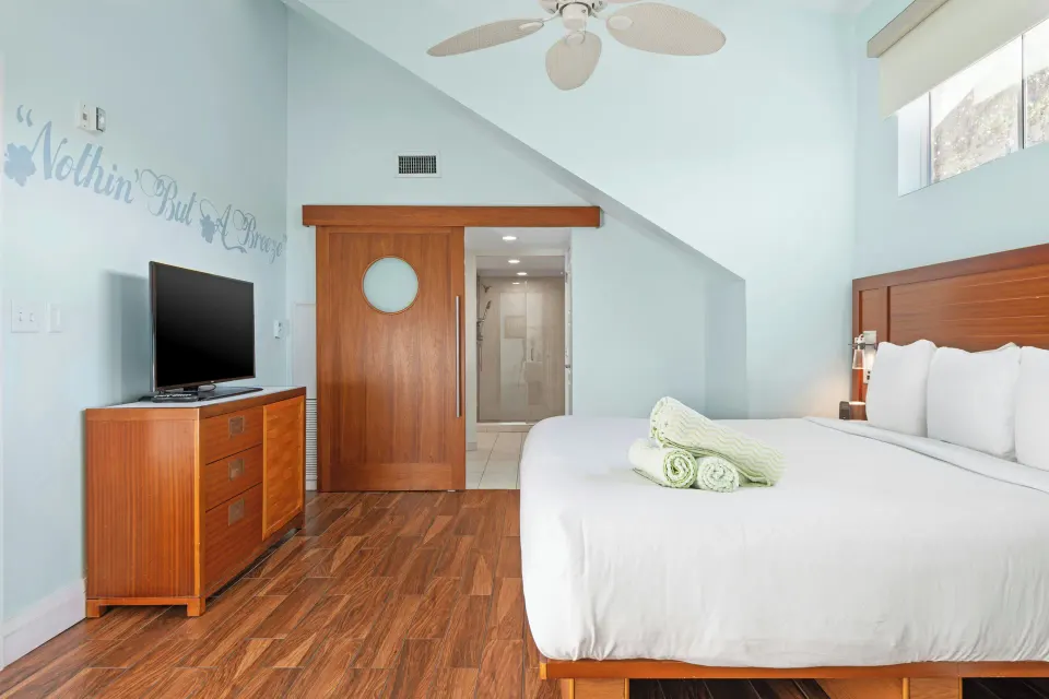 Bedroom with king bed and bathroom entry at Margaritaville Vacation Club - St. Thomas.