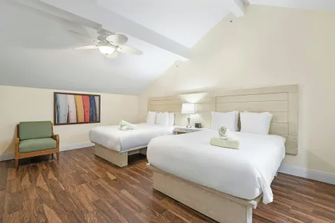 Bedroom with two beds under a sloped ceiling at Margaritaville Vacation Club - St. Thomas.