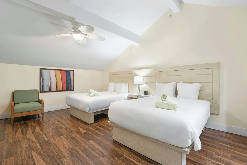 Bedroom with two beds under a sloped ceiling at Margaritaville Vacation Club - St. Thomas.