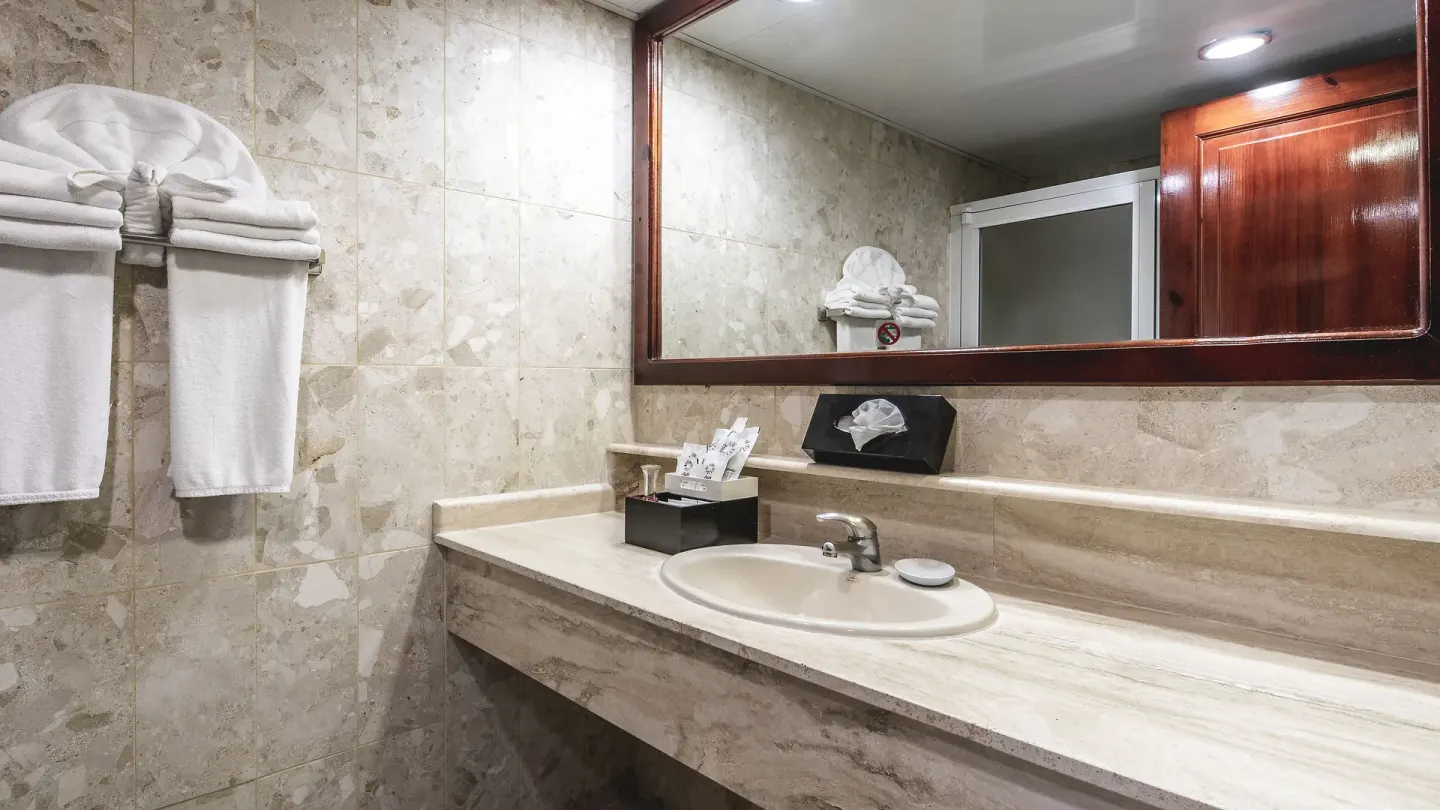 Guest bathroom vanity with towels and large mirror at Marien Puerto Plata.