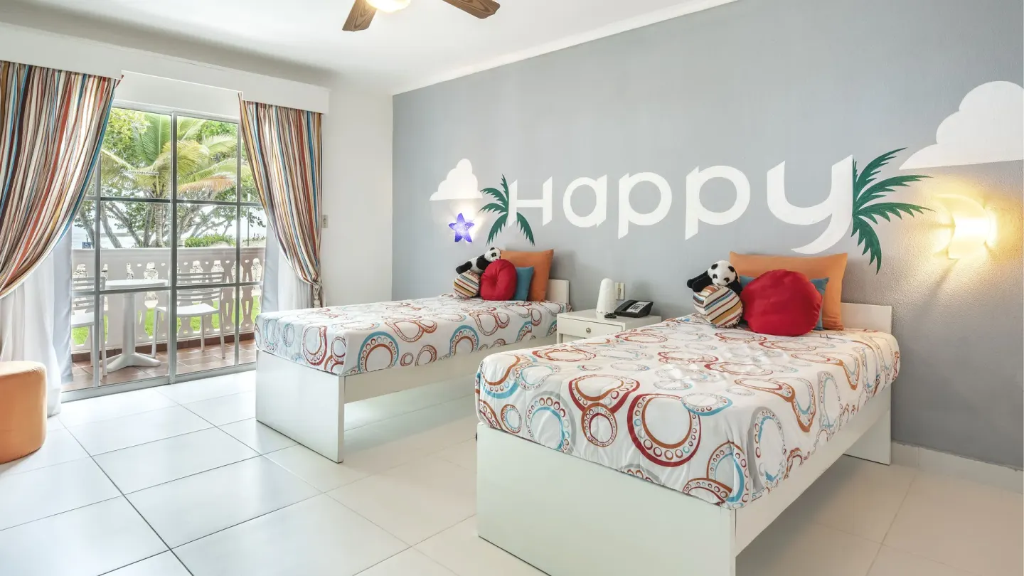 Kids' room with two beds, balcony, and playful wall art at Marien Puerto Plata.