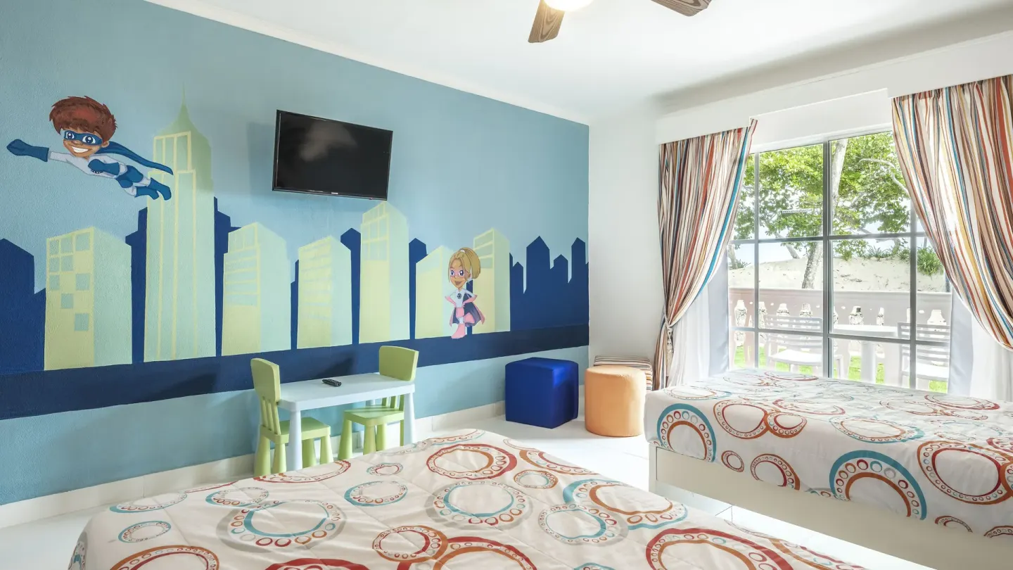 Kids' room with two beds, city mural, TV, and balcony at Marien Puerto Plata.