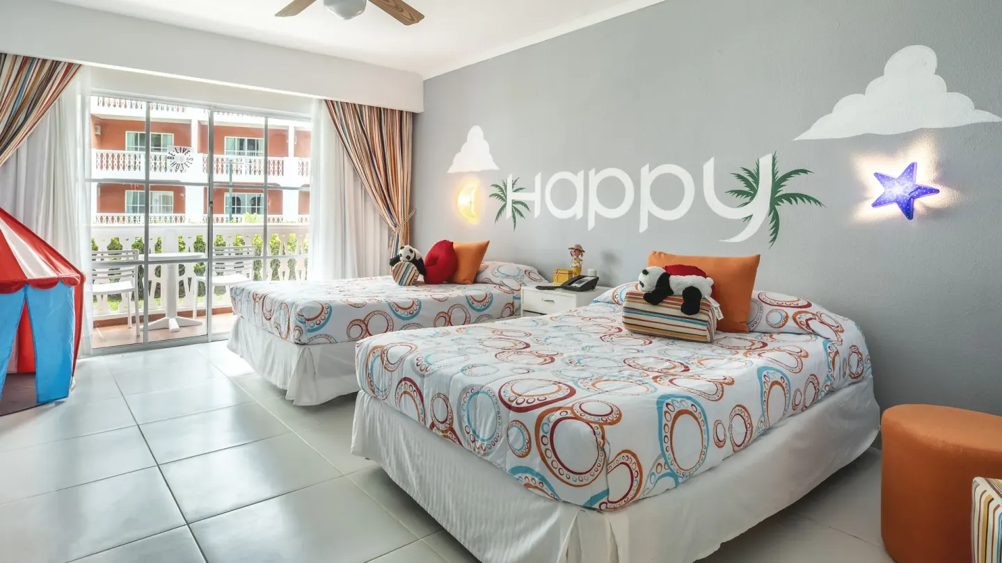 Kids' room with two beds, play tent, balcony, and happy wall art at Marien Puerto Plata.