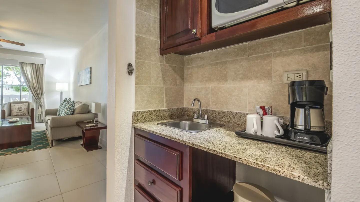 Suite kitchenette with sink, coffeemaker, microwave, and living area at Marien Puerto Plata.