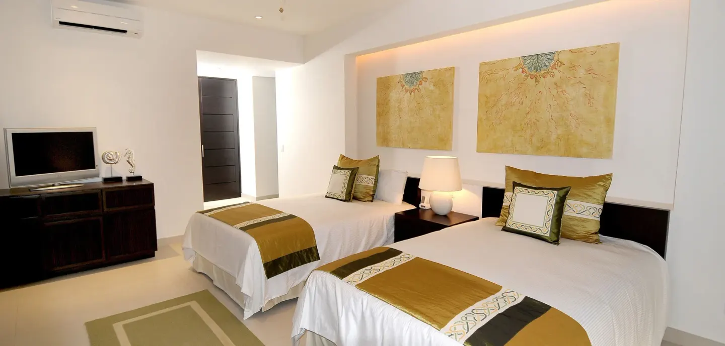 Bright guest room with two double beds and a TV console at Marival Distinct World Spa.