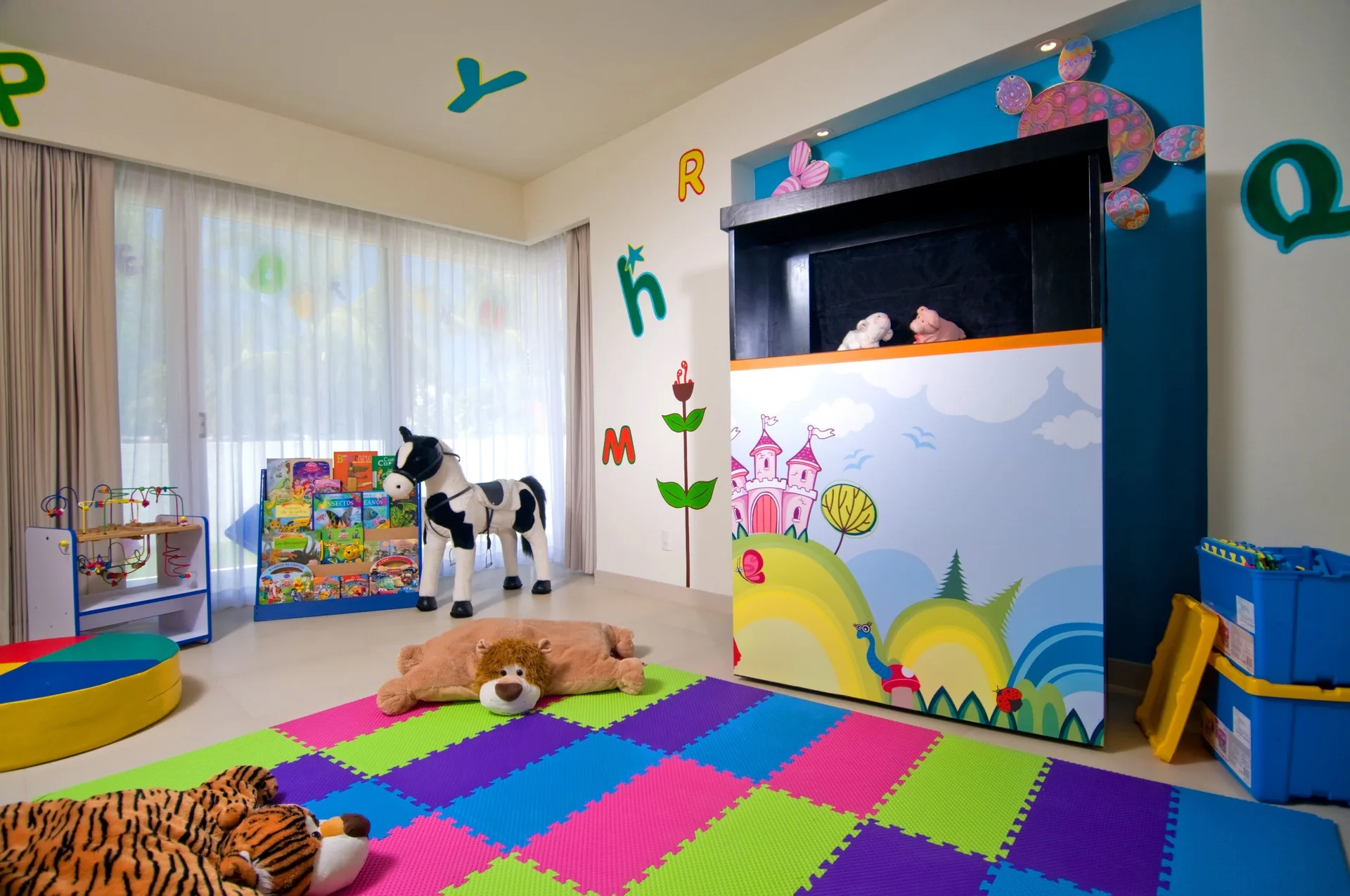 Kids club playroom with foam mats, toys and puppet stage at Marival Distinct World Spa.