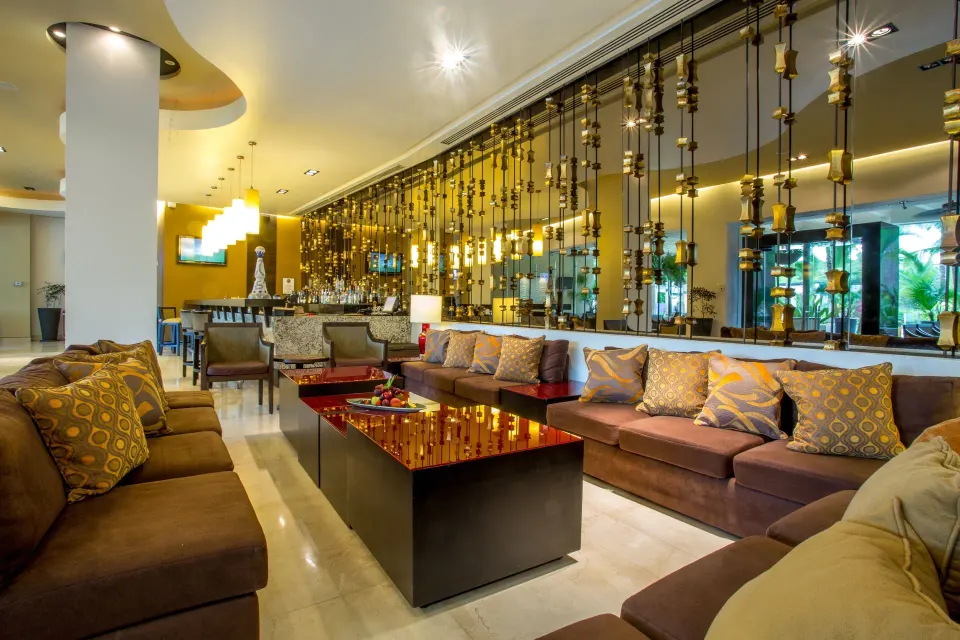 Lounge seating and bar area with gold screen accents at Marival Distinct World Spa.
