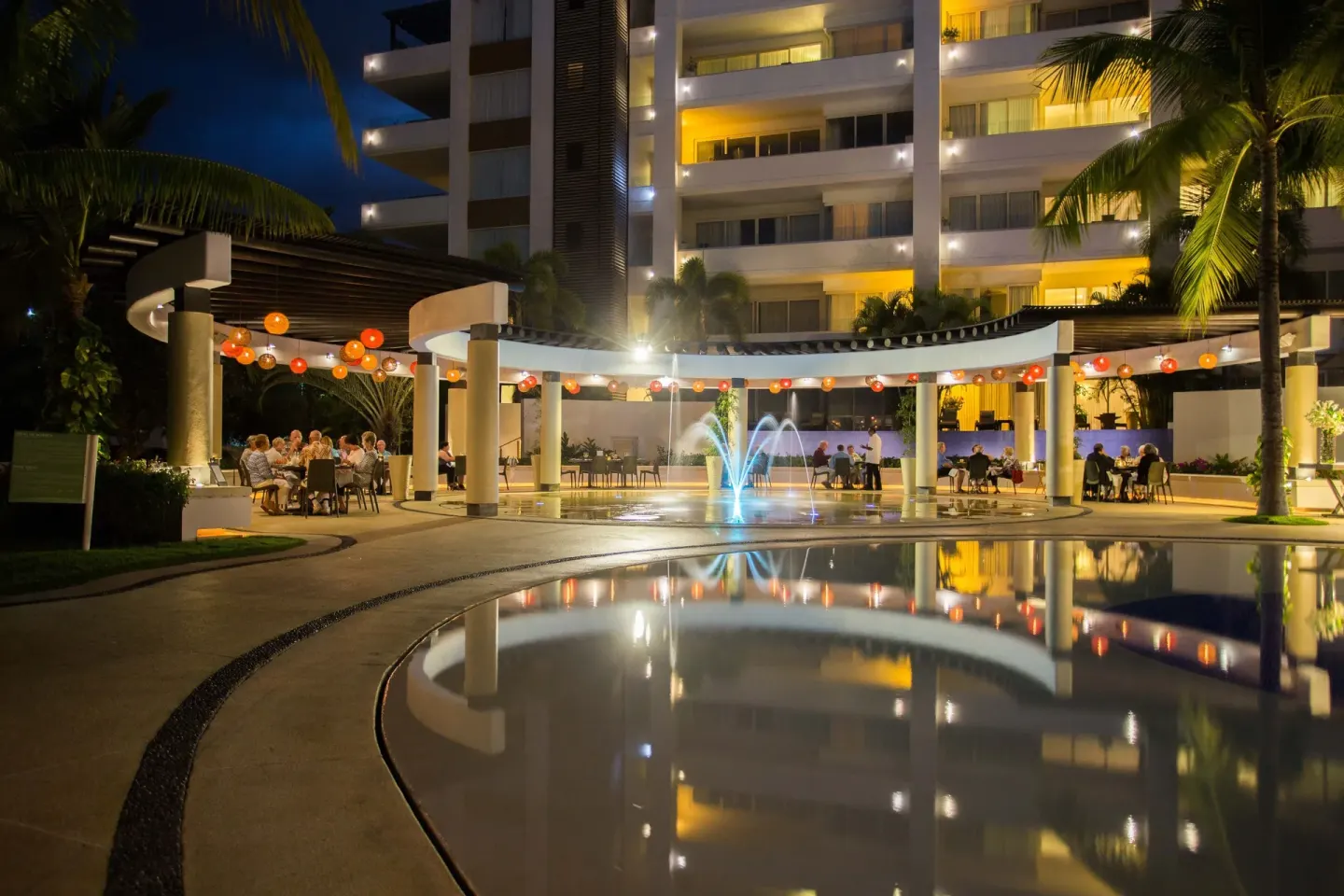 Nighttime courtyard pool with fountain and lanterns at Marival Distinct World Spa.
