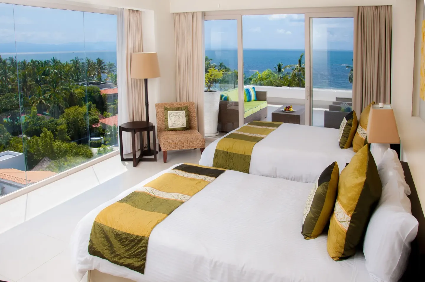 Guest room with two beds, ocean views, and a balcony at Marival Distinct World Spa.