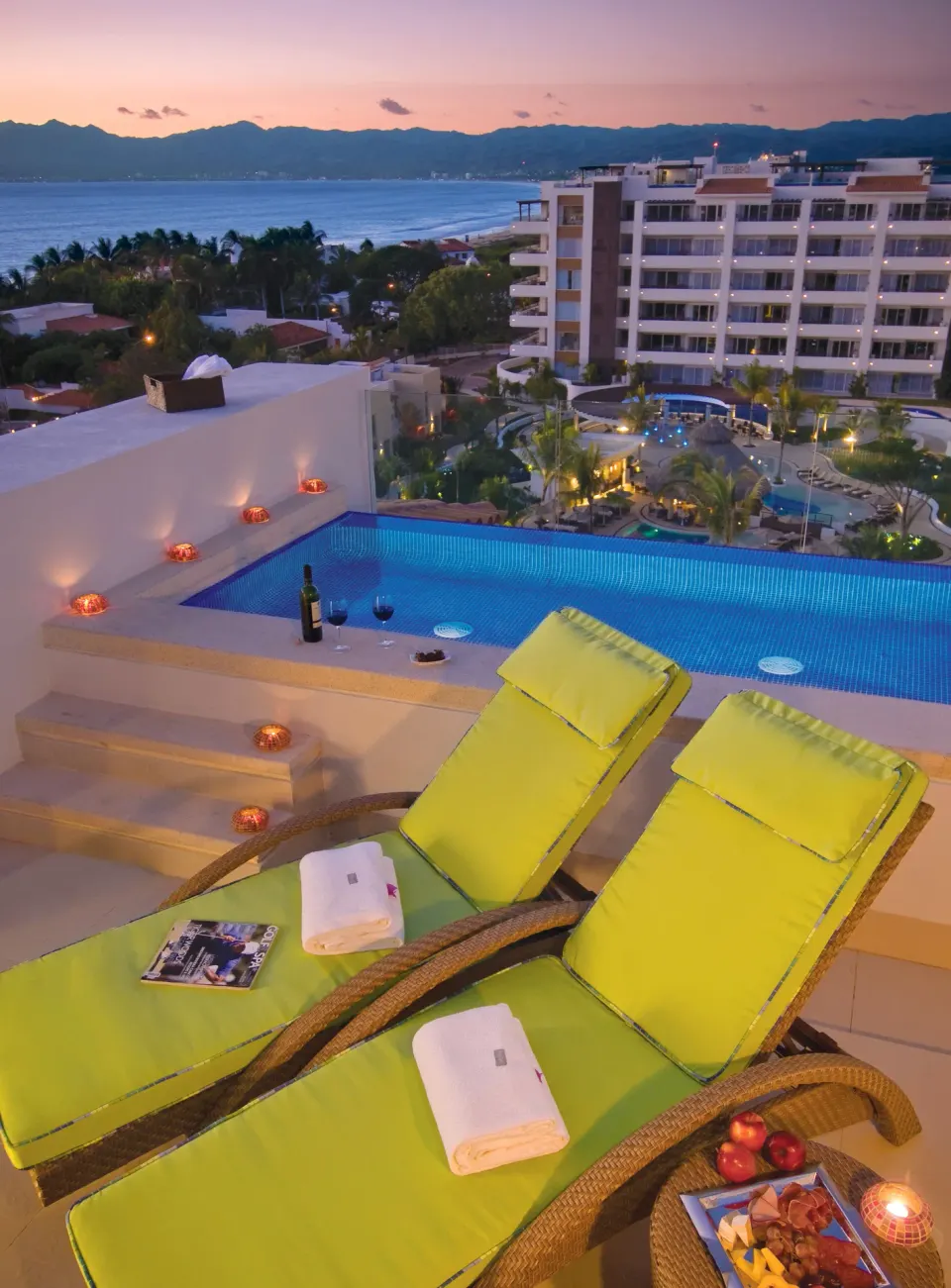 Rooftop pool deck with loungers and bay view at Marival Distinct World Spa.