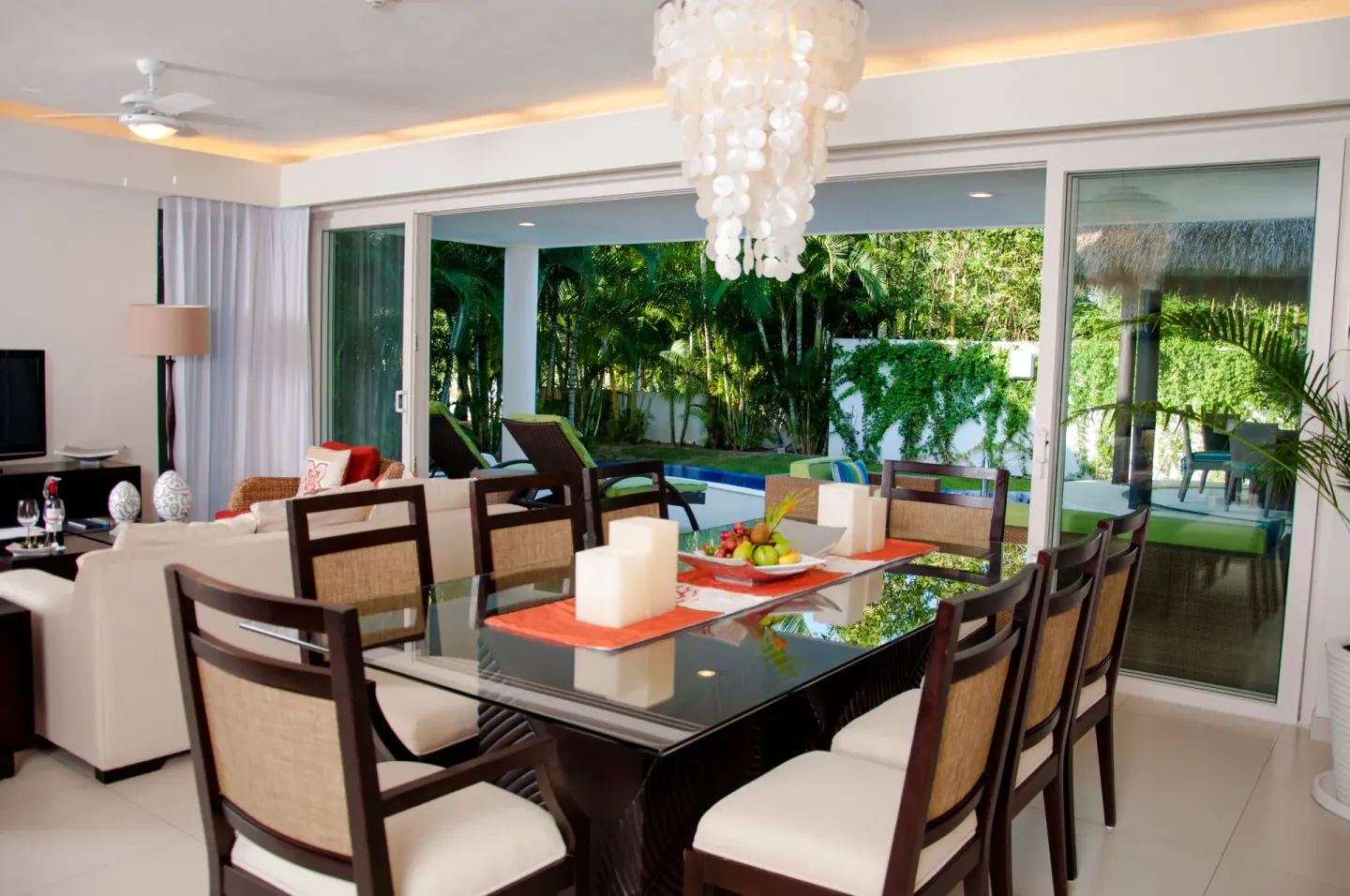 Suite dining table facing sliding doors to a garden and pool at Marival Distinct World Spa.