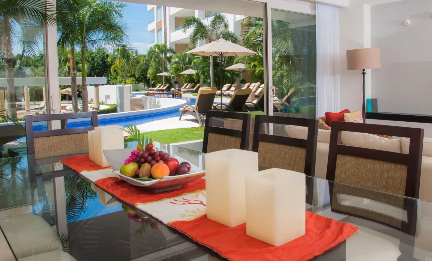 Suite dining table beside sliding doors and a pool terrace at Marival Distinct World Spa.