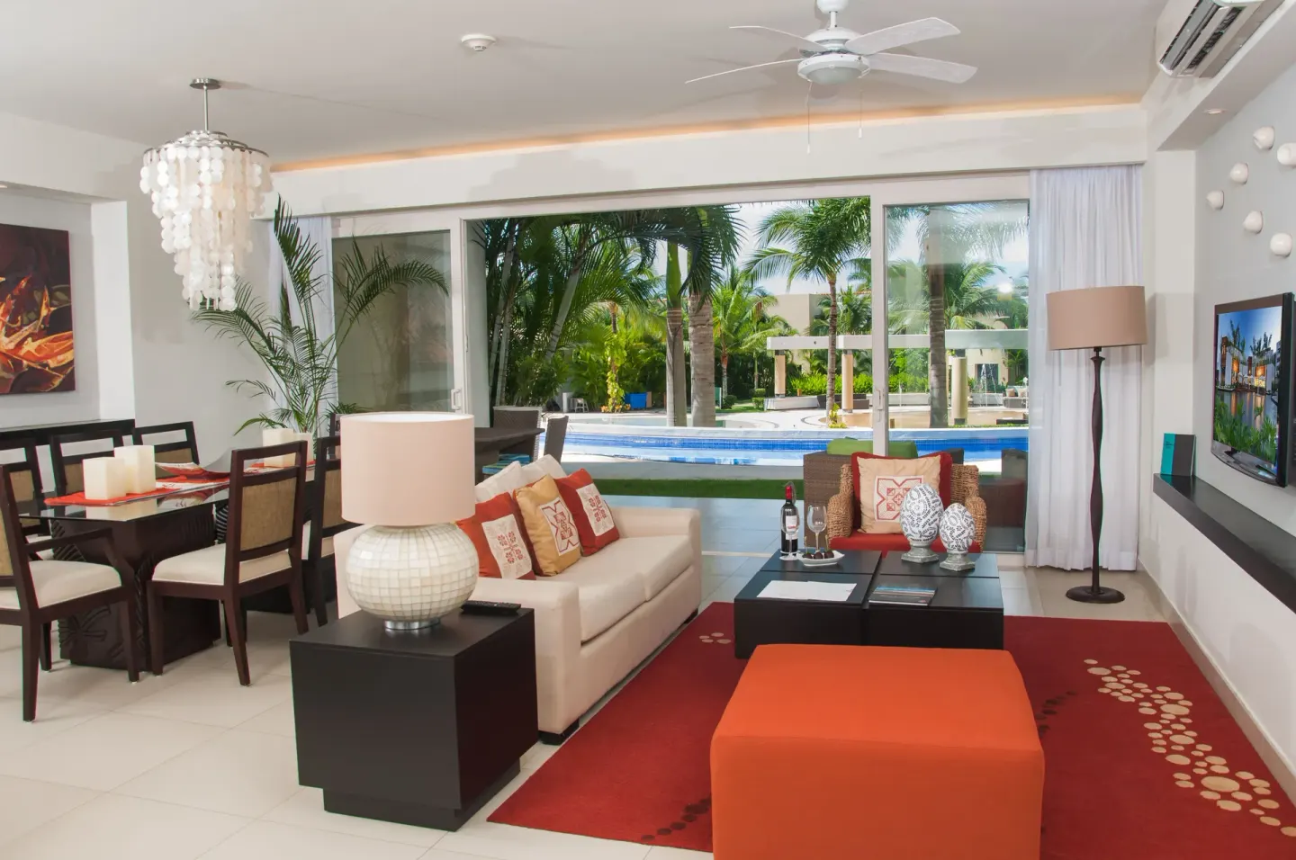 Living and dining area with pool-facing glass doors at Marival Distinct World Spa.