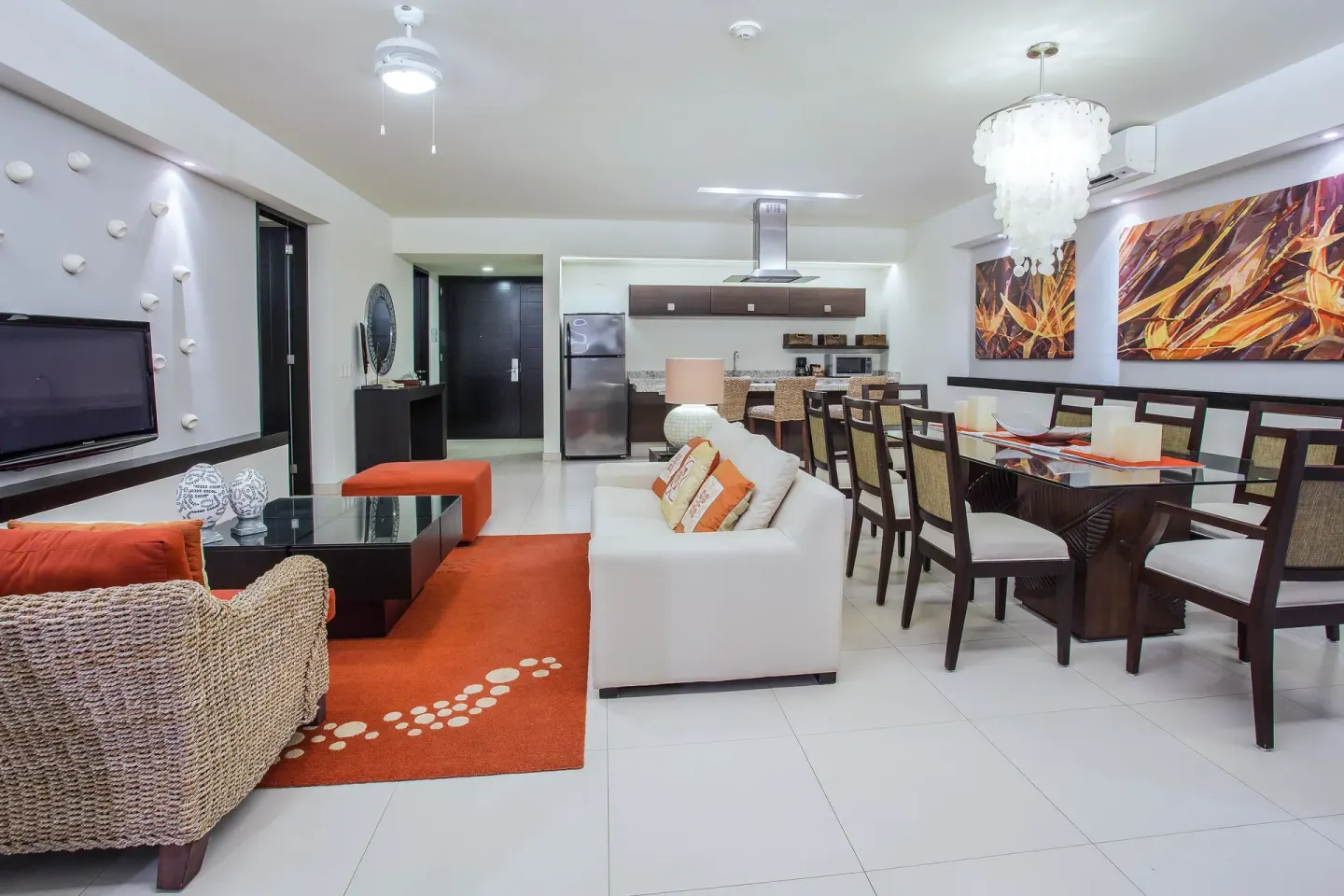 Open-plan suite lounge, dining table, and kitchen at Marival Distinct World Spa.