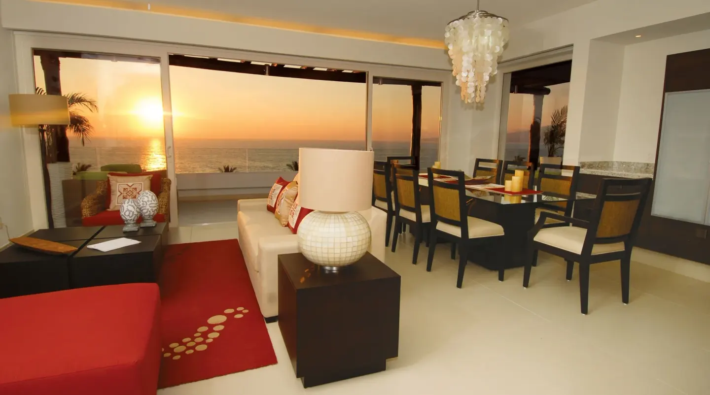 Suite living and dining area with sunset ocean view at Marival Distinct World Spa.