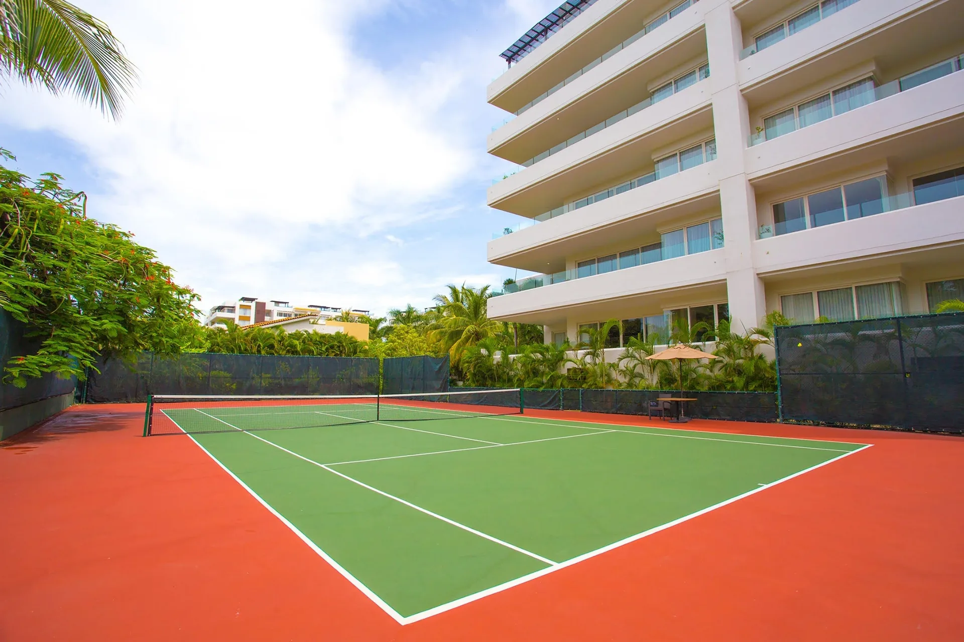 Tennis court beside a guest building at Marival Distinct World Spa.