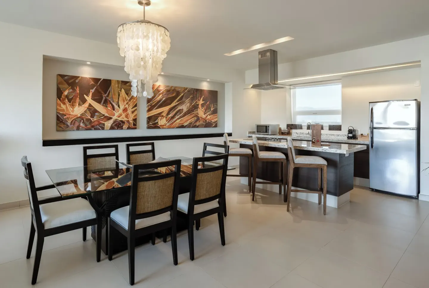One-Bedroom Ocean View Suite dining table and kitchen at Marival Distinct World Spa.