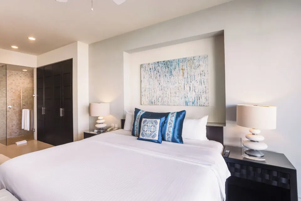 One-Bedroom Ocean View Suite king bed and glass shower at Marival Distinct World Spa.