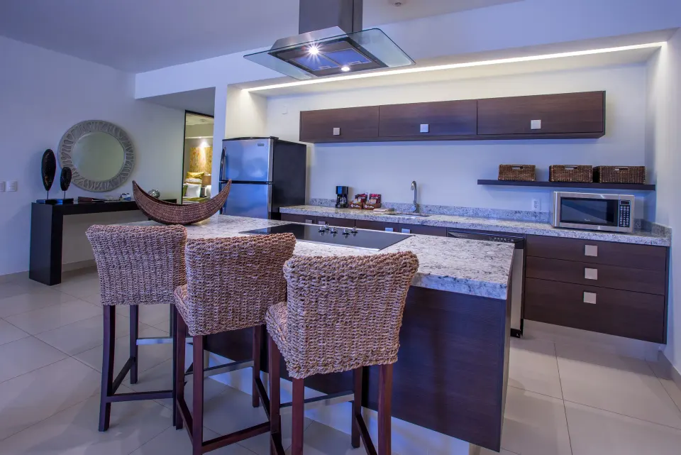 One-Bedroom Ocean View Suite kitchen island and wicker stools at Marival Distinct World Spa.