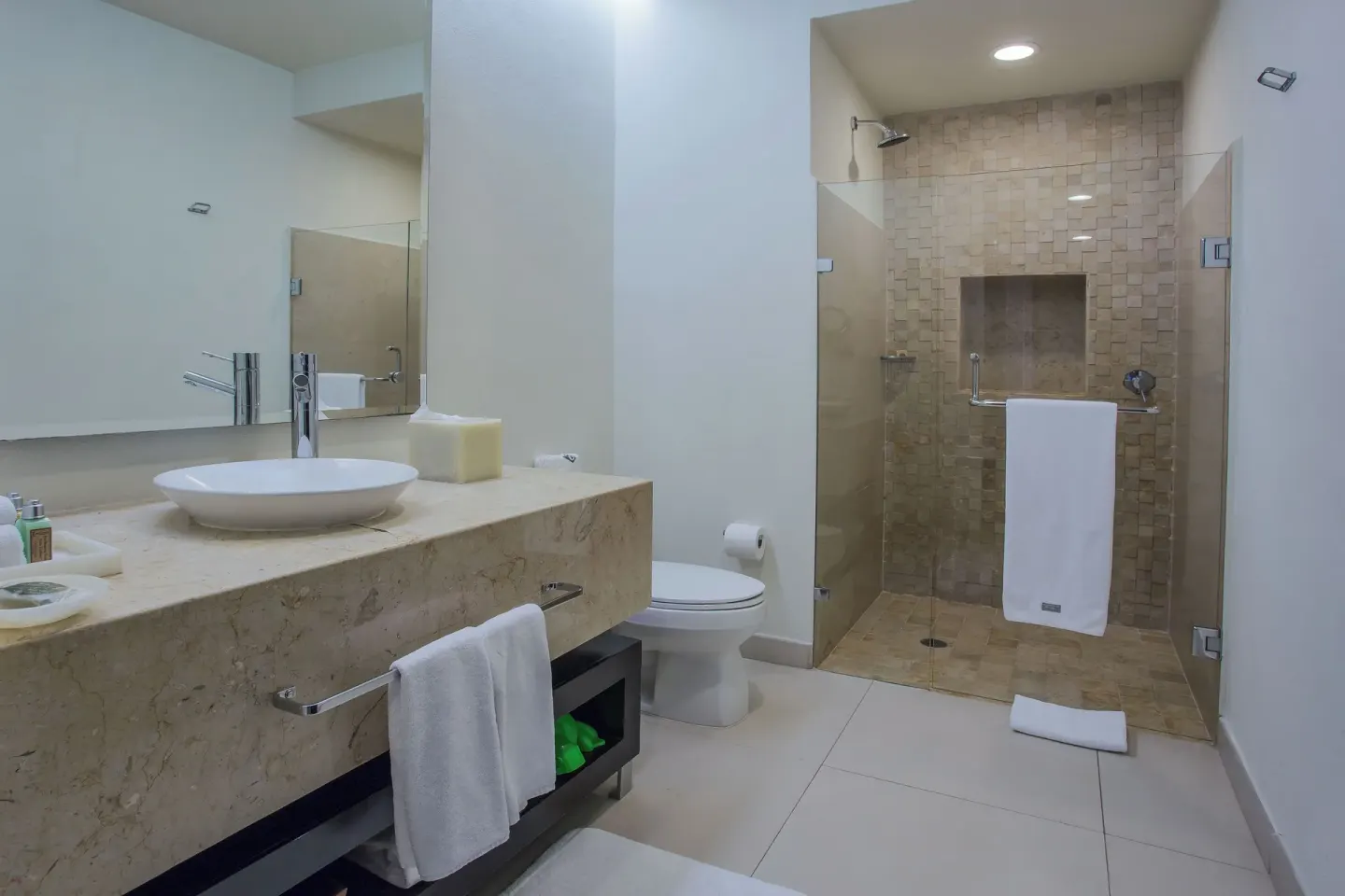 Bathroom with vessel sink and glass shower in Three-Bedroom Suite 2 at Marival Distinct World Spa.