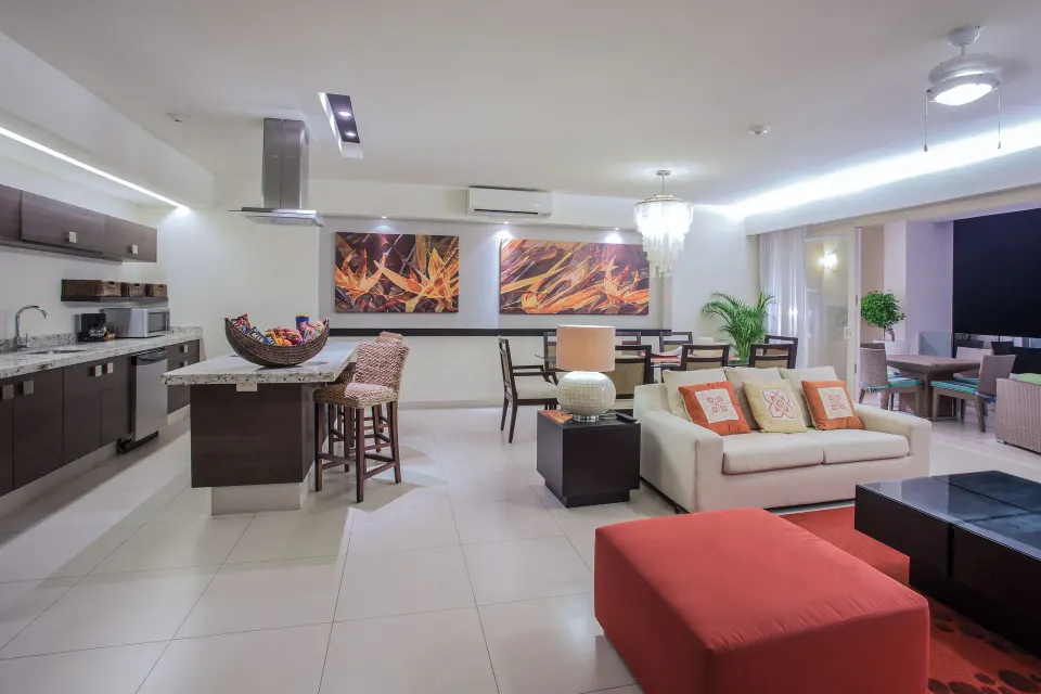 Open kitchen, dining, and lounge area in Three-Bedroom Suite 2 at Marival Distinct World Spa.